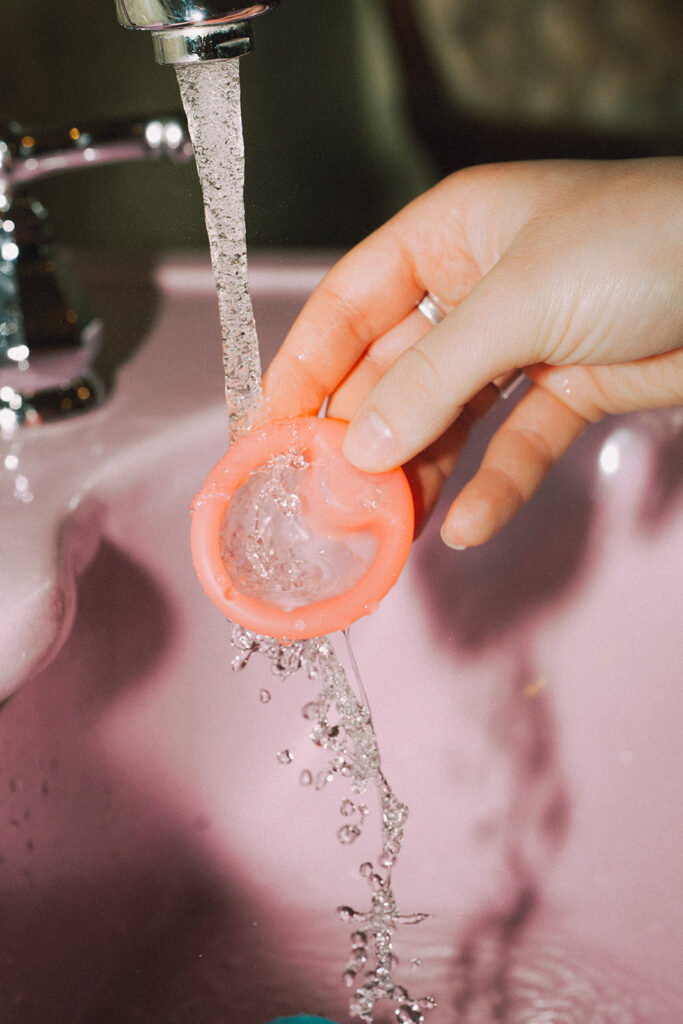 Garnuu product rinsed under running water in pink sink close-up, clean and playful brand photoshoot imagery.