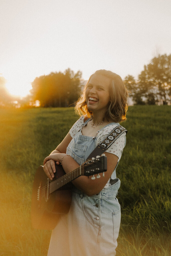 Senior photos at golden hour with artistic musician wearing denim overalls and pigtails