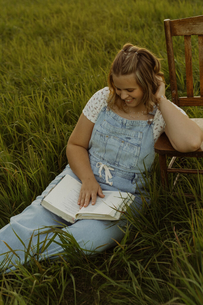 High schooler reads her Bible while sitting in Minnesota field