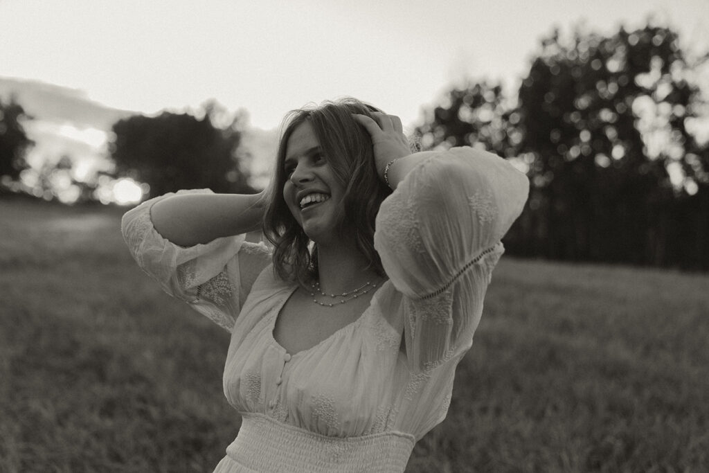 Young girl wearing white peasant blouse looks off into the distance in senior photos