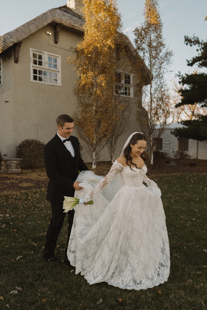 Bride twirls like a princess while groom holds her train on the lawn at Edward Anne Estate historic wedding venue in Chaska, Minnesota