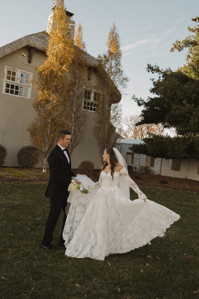 Bride twirls on the lawn of Edward Anne Estate while groom looks on with adoration