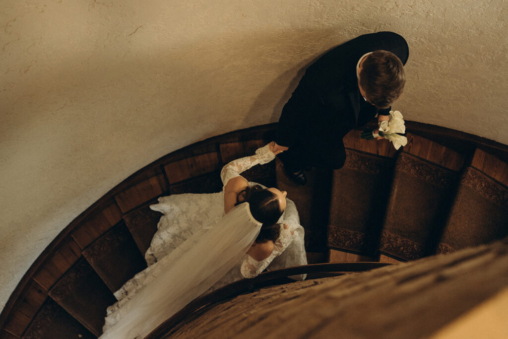 Bride and groom walk up grand staircase of historic wedding venue Edward Anne Estate