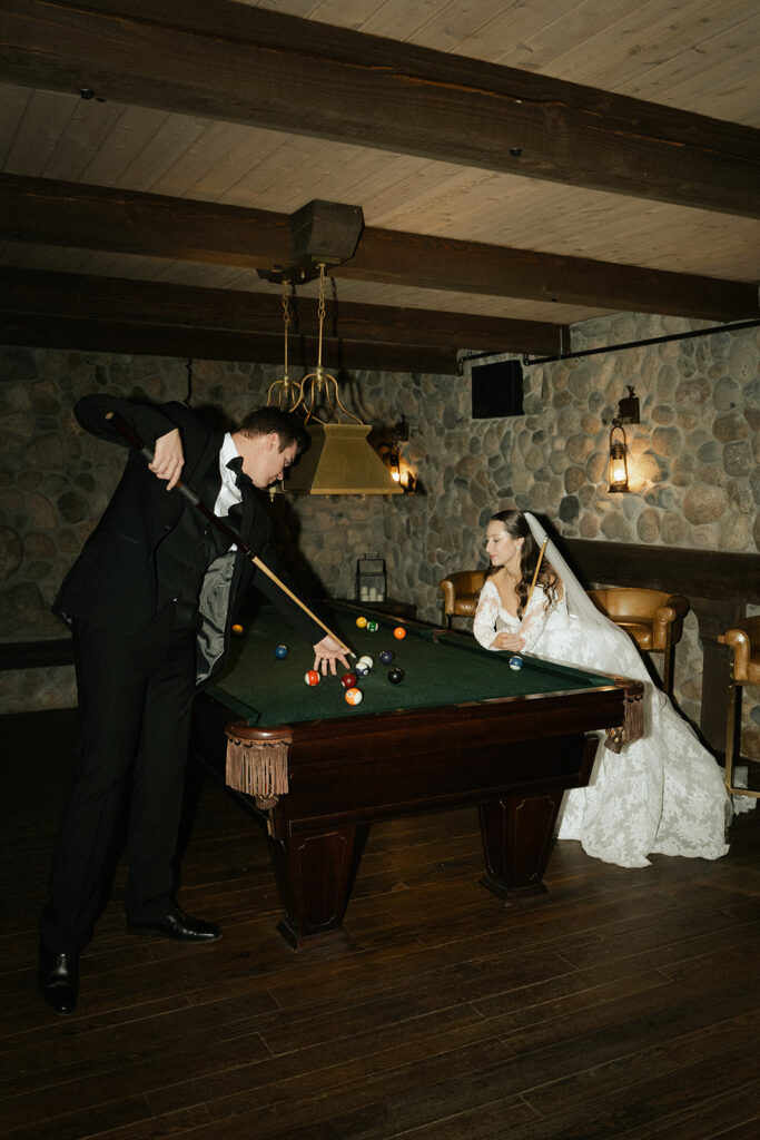 Eclectic shot of bride and groom playing pool in groom's suite at historic wedding venue Edward Anne Estate in Chaska, Minnesota