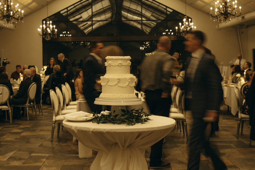 Elegant two-tiered white wedding cake serves as the centerpiece at Edward Anne Estate wedding in Minnesota