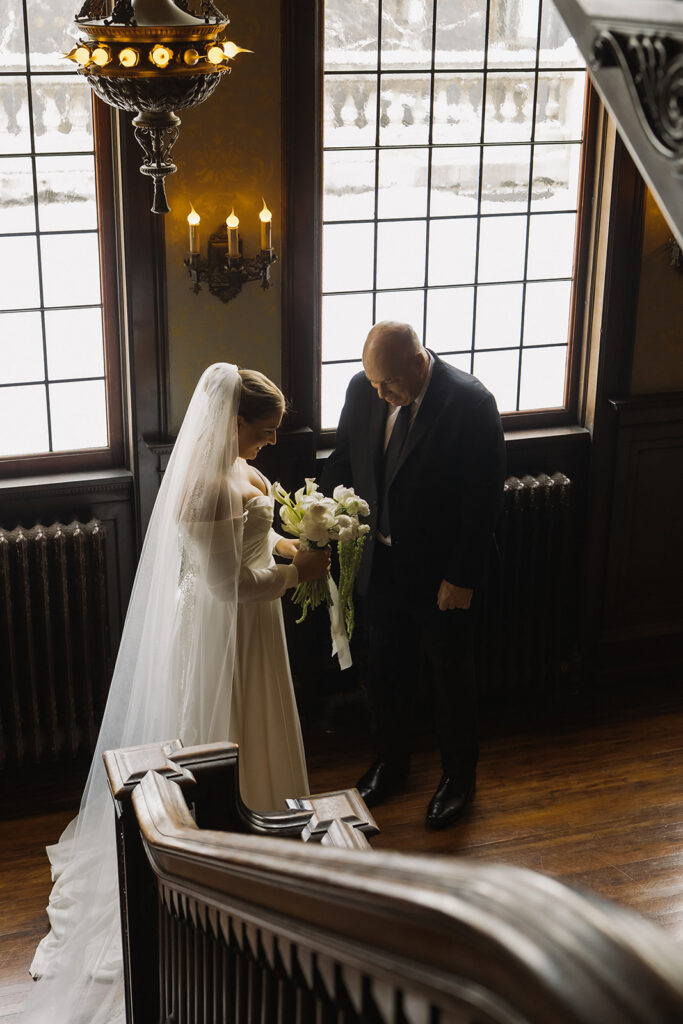 Bride's father exclaims over bride's bouquet on mansion threshold