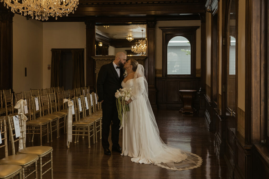 Bride and groom share a kiss in ceremony space at historic wedding venue in Saint Paul, Minnesota