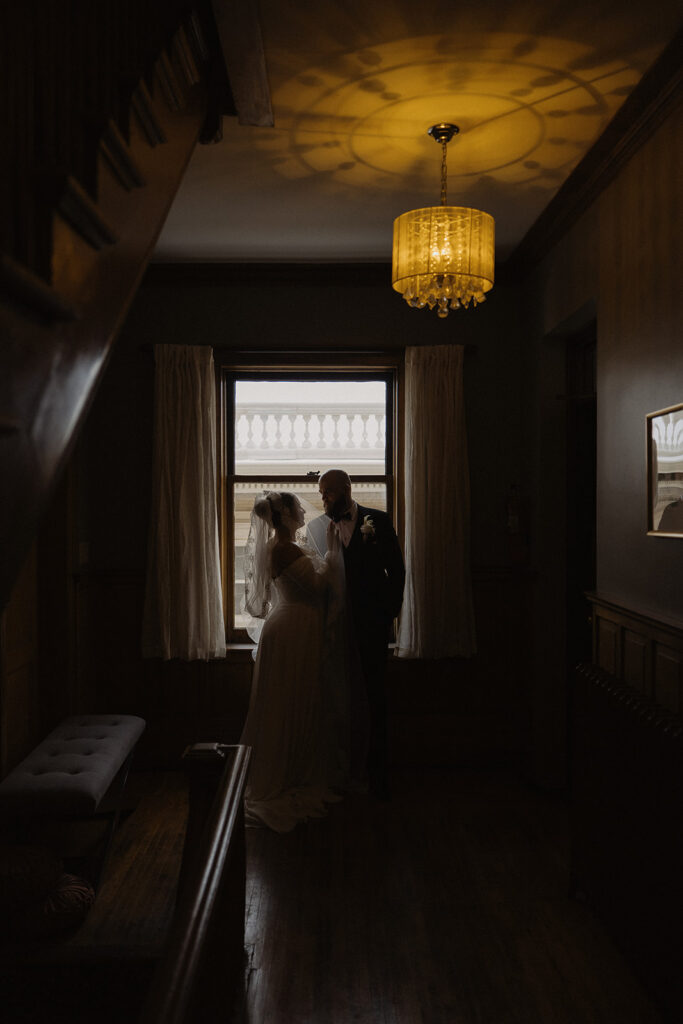 Dramatic portrait of bride and groom silhouettes at historic wedding venue in Saint Paul, Minnesota