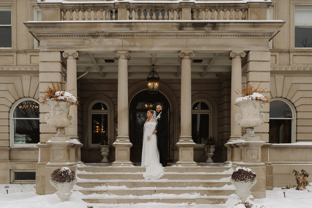 Bride and Groom stand in stately pose in regal entrance of Semple Mansion