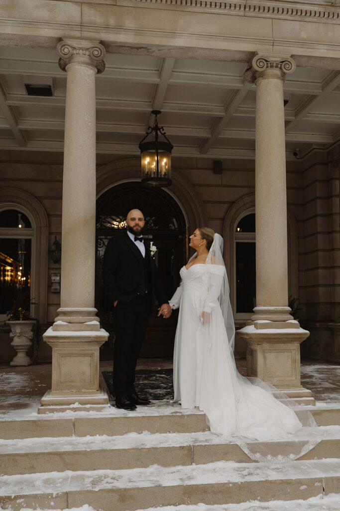 Bride and groom pose in stately portrait outside historic wedding venue in Minnesota