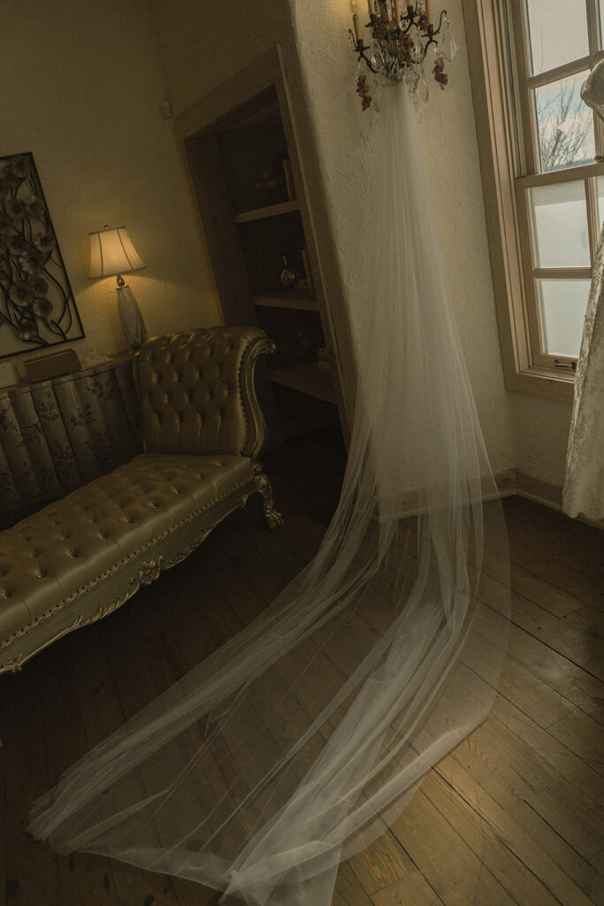 Veil lays draped across hardwood floor at mansion wedding venue in Chaska, Minnesota