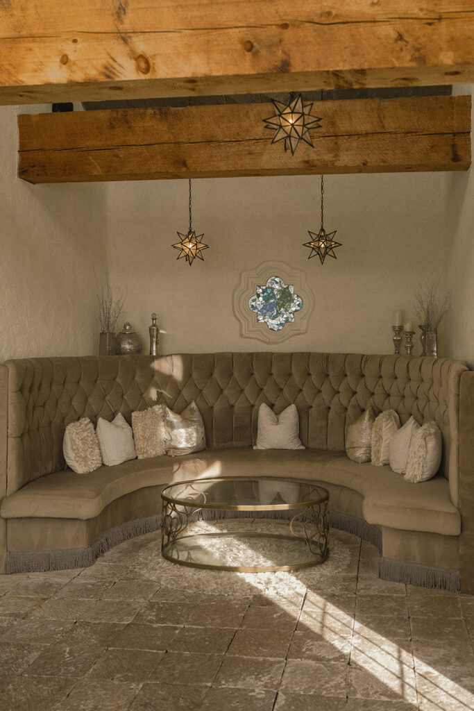 Elegant, luxe lounge area in Edward Anne Estate bridal suite, complete with a taupe banquette and glass coffee table