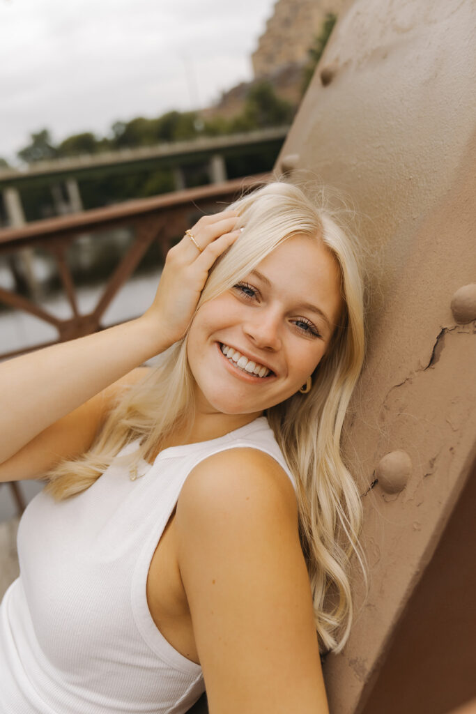 Senior photo inspiration for the chill, cool girl wearing white tank top and denim jeans