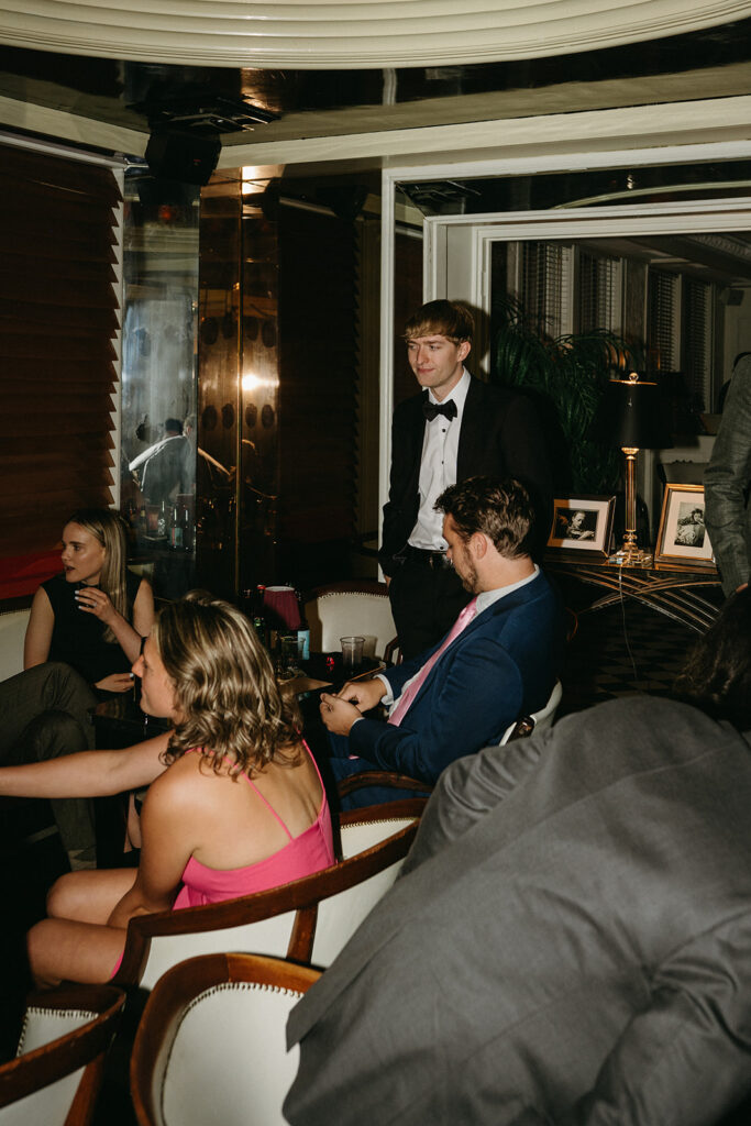 Groom socializes with guests during cocktail hour at historic wedding venue in Minnesota