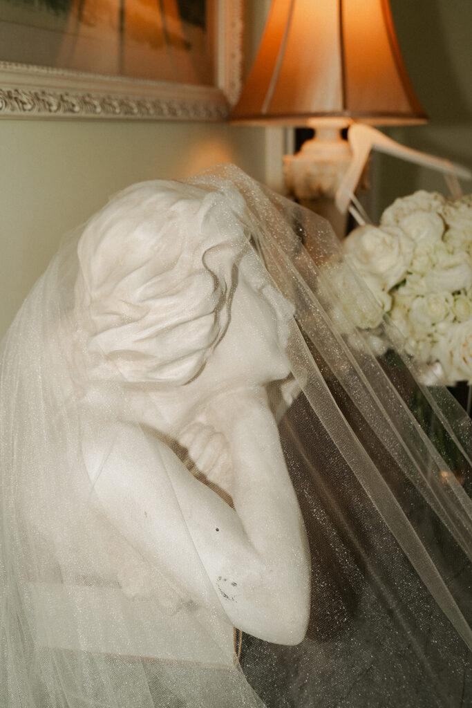 Bride's veil lays draped over stone bust at Van Dusen Mansion