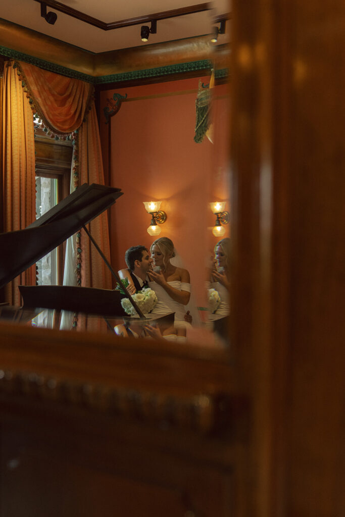 Newlyweds enjoy a private, intimate moment at the piano in Van Dusen Mansion