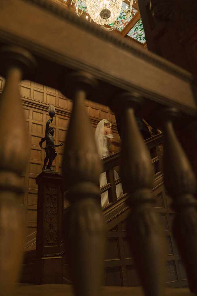 Bride captured through the staircase rungs as she makes her way up the stairs