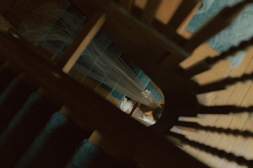 Aerial view of bride's veil trailing down the staircase of Van Dusen Mansion in Minneapolis